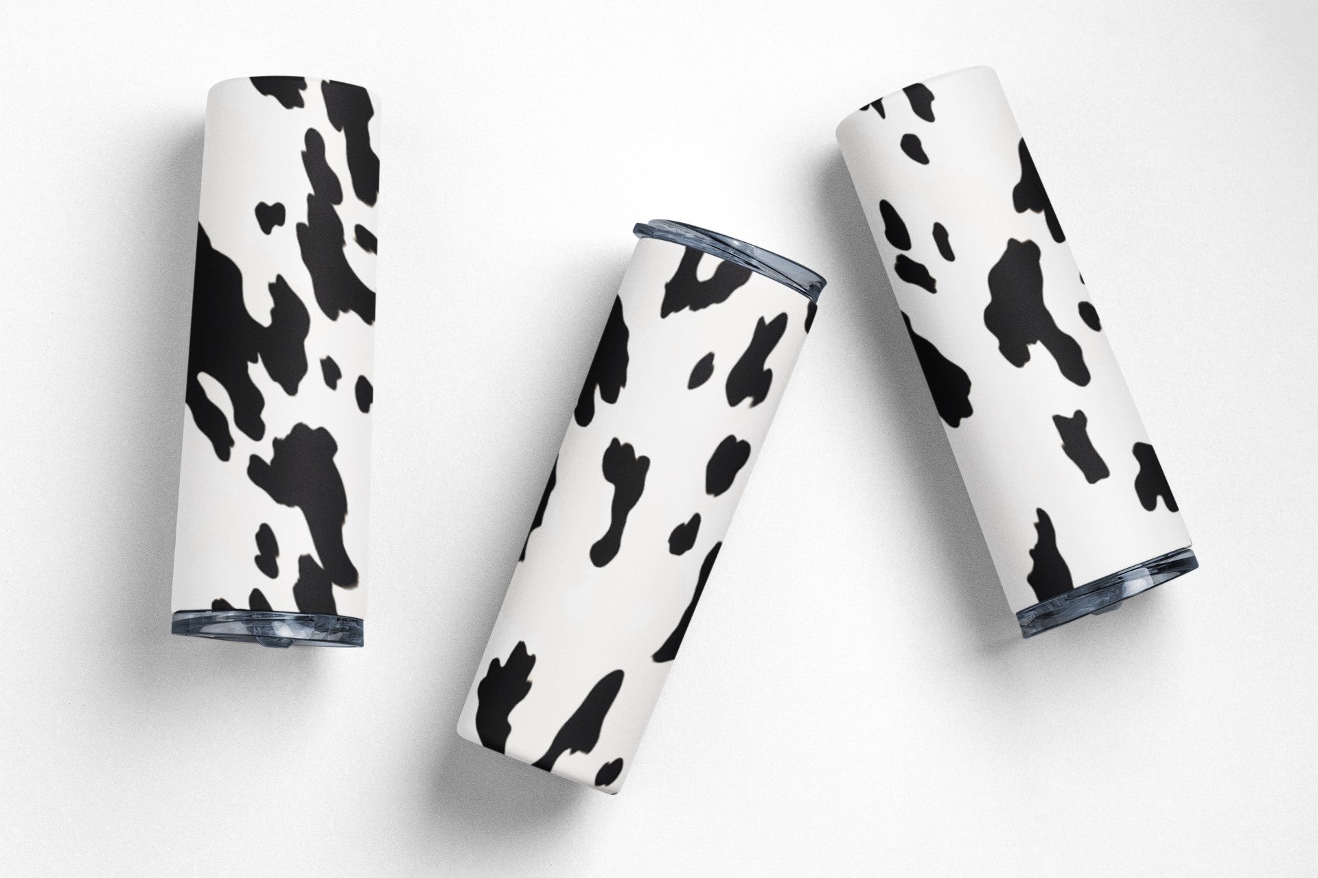 Four tumblers with cow print design on a white background