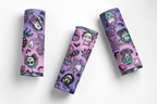 Three slim cylindrical cosmetic tubes with a purple and pink Halloween-themed pattern featuring skulls, ghosts, spiders, and bats, arranged on a clean white background.
