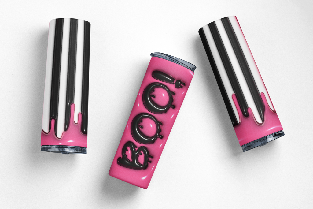 Three slim cylindrical tumbler-style cups with a glossy pink and black drip design, arranged on a clean white background. The center cup is upright and features the word "BOO" in large black letters over a bright pink background, while the two side cups are angled and show the black-and-white drip pattern with pink at the bottom.