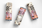 Three cylindrical cosmetic tubes with Halloween-themed designs, including ghosts, bats, spiderwebs, and checkered patterns, arranged on a clean white background.