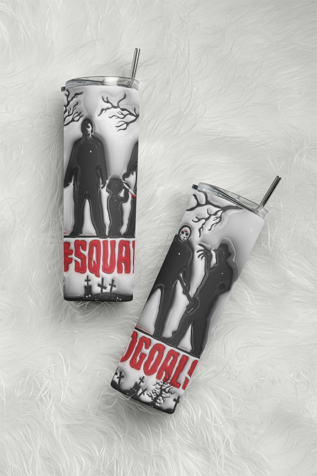 Two insulated tumblers with clear lids and metal straws, printed with black-and-white horror character silhouettes, bare tree branches, and red text, arranged on a white faux-fur surface.
