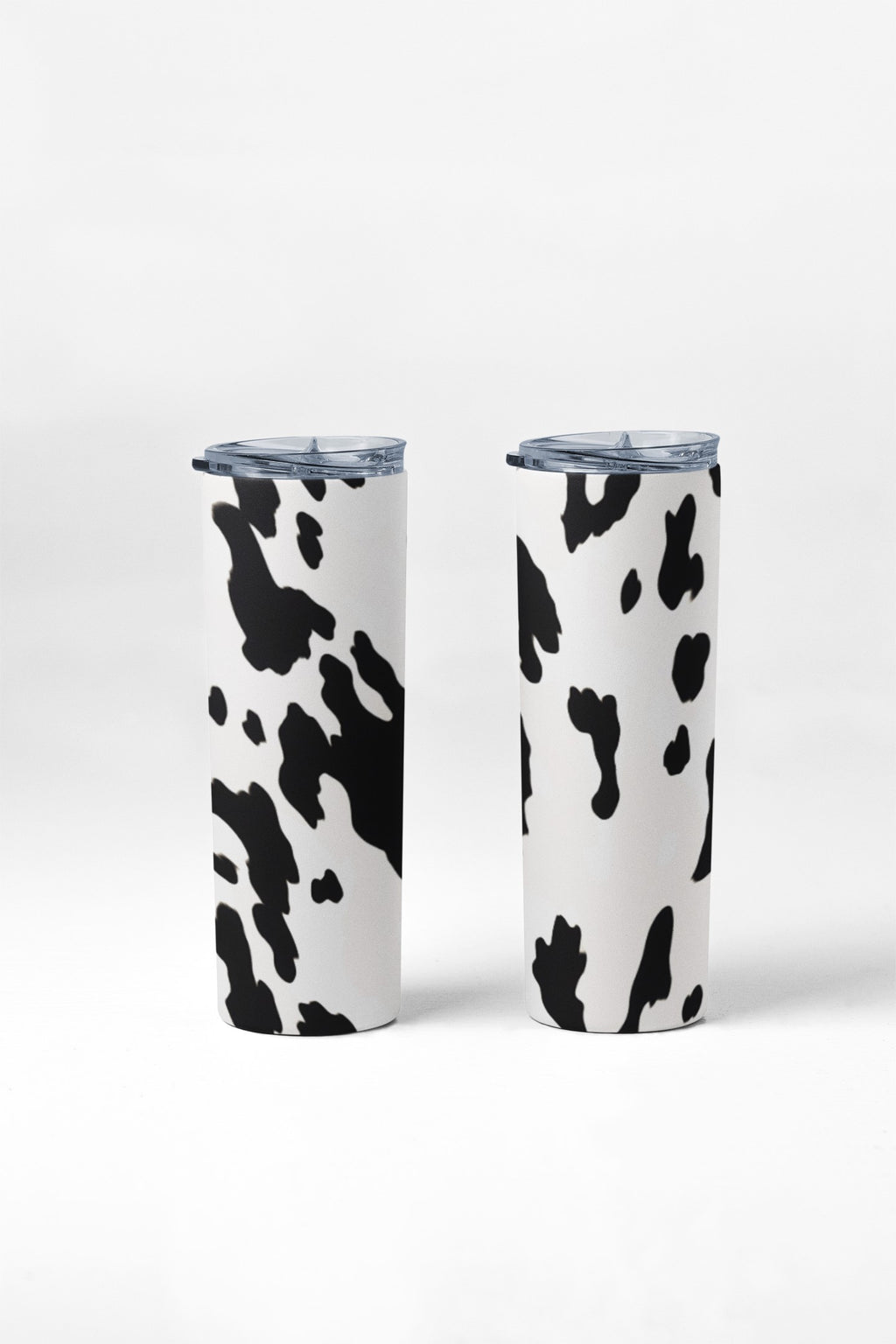 Two tumblers with cow print design on a white background