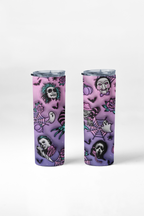Two slim travel tumbler cups with clear lids, decorated with a purple and pink Halloween-themed pattern featuring skulls, ghosts, spiders, bats, and a ghost face, shown on a light gray background.