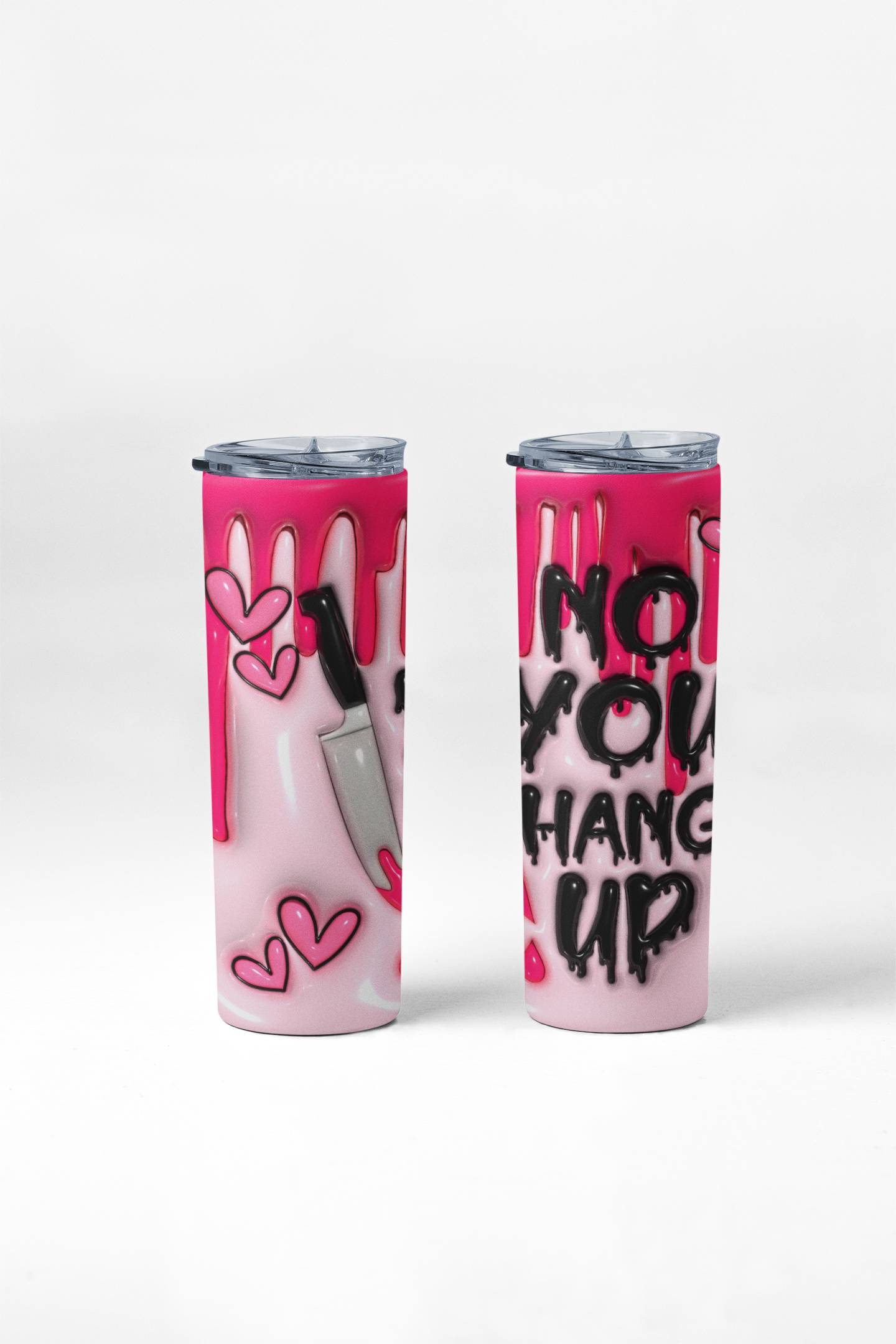 Two pink insulated tumbler cups with clear lids, shown on a clean white background. One cup features a dripping pink design with pink hearts and a knife graphic, while the other displays black graffiti-style text reading 'NO YOU HANG UP'.