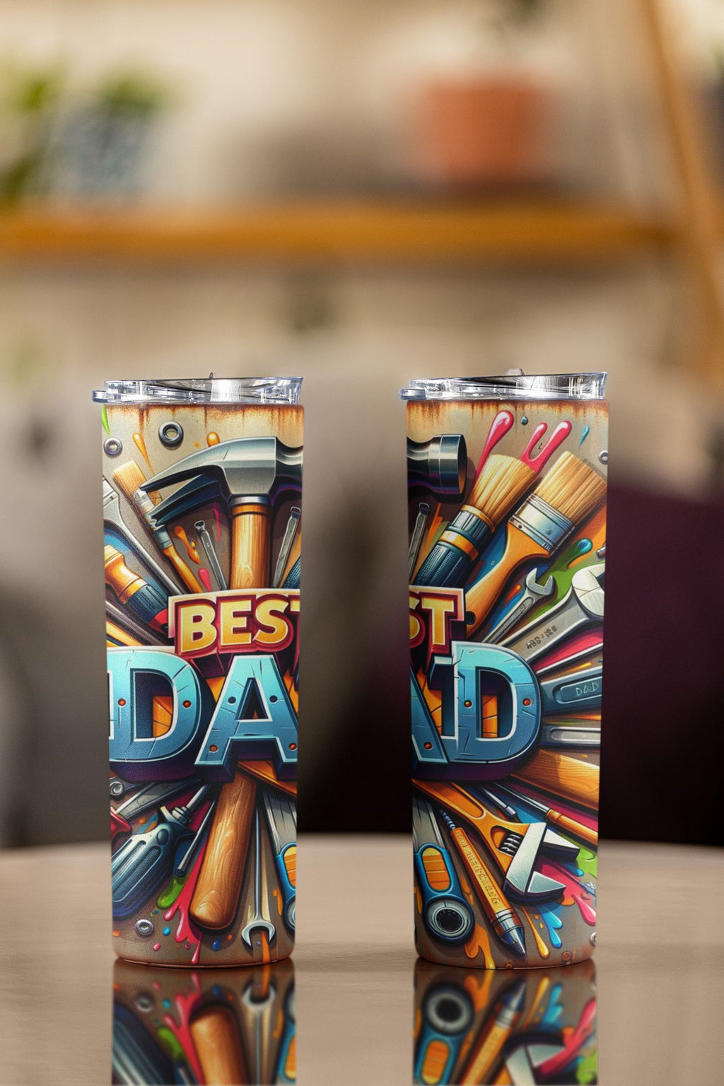Two colorful tumblers with tool-themed design and 'Best Dad' text on a blurred background.