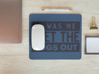 Blue mouse pad with humorous text on a wooden desk