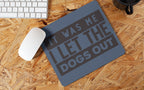 Mouse pad with humorous text on a wooden desk with a keyboard and mouse.