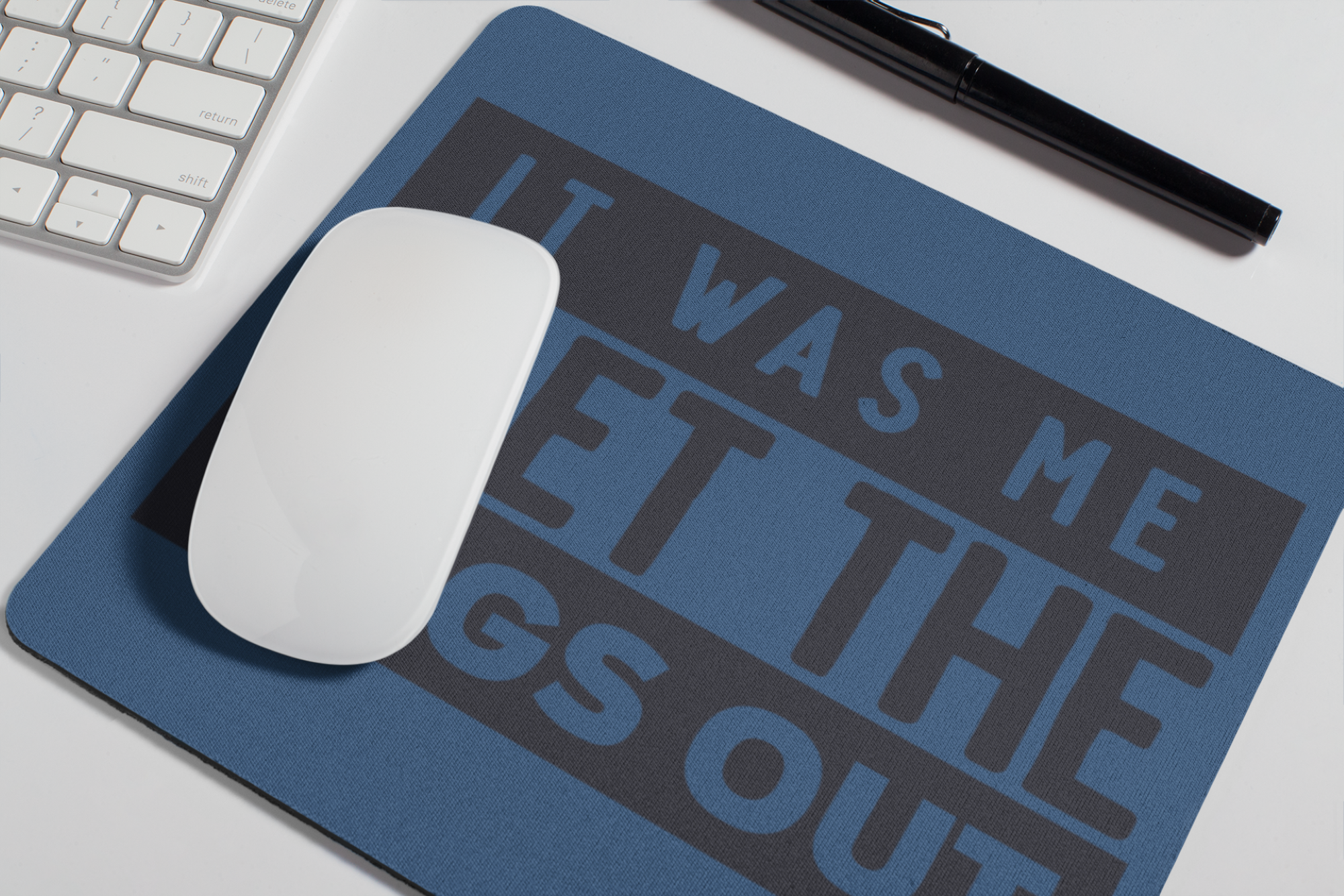 Blue mouse pad with text on a desk with a computer mouse and keyboard.
