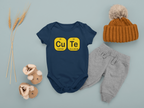 Baby outfit with navy onesie, gray pants, and brown hat on a light blue background