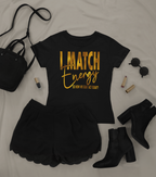 Black t-shirt with 'I Match Energy' text, black skirt, black boots, and accessories on a light gray background