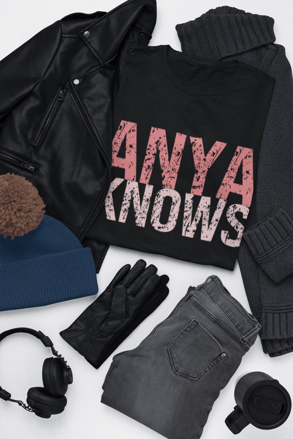 Black sweatshirt with 'ANYA KNOWS' text, leather jacket, beanie, gloves, jeans, and headphones on a white background