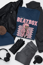 Navy blue t-shirt with 'The Beatbox' design on a white surface with black leather jacket, gray jeans, black gloves, and headphones.