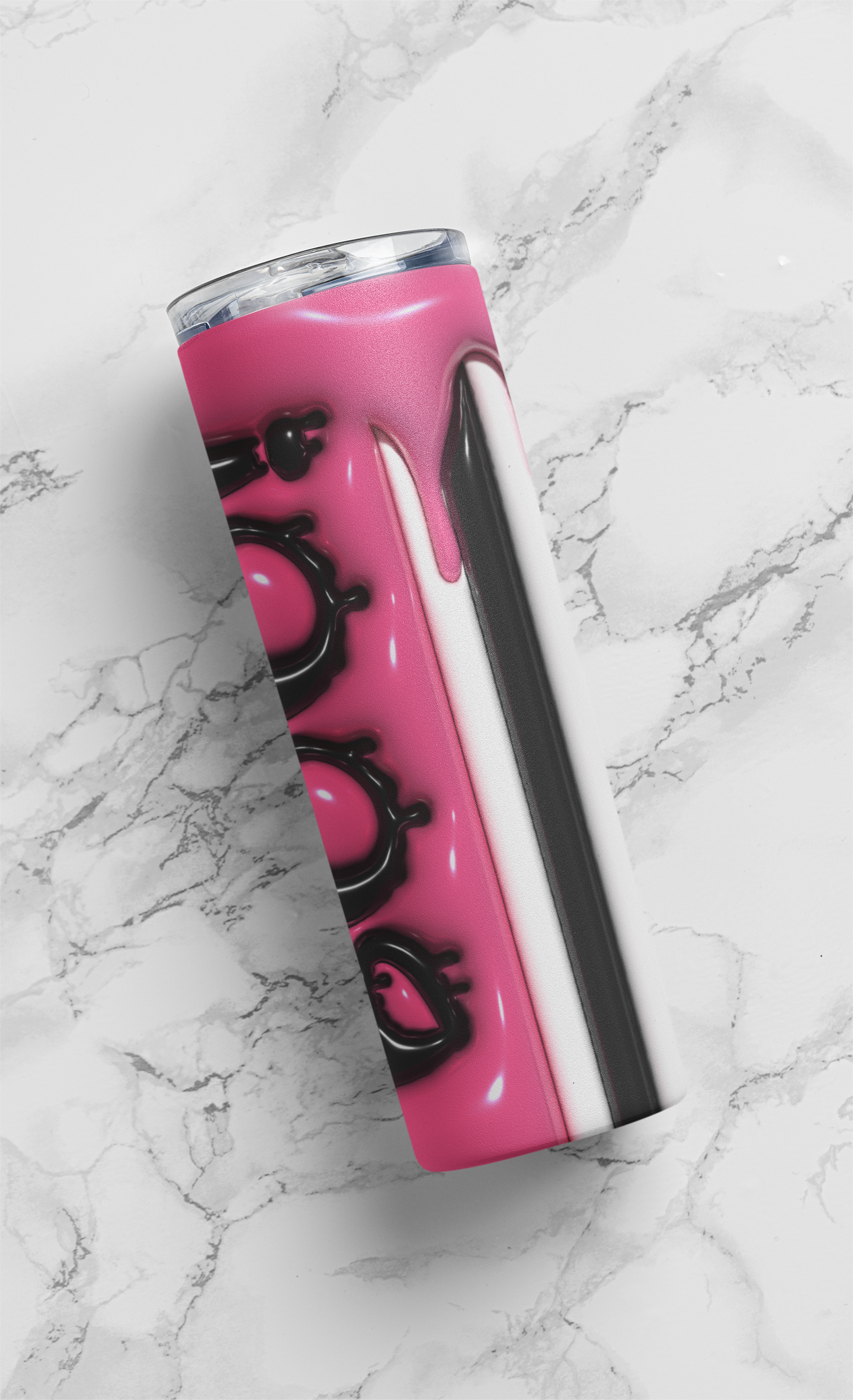 A pink travel tumbler with black graphic designs and a silver rim, shown on a white marble background.