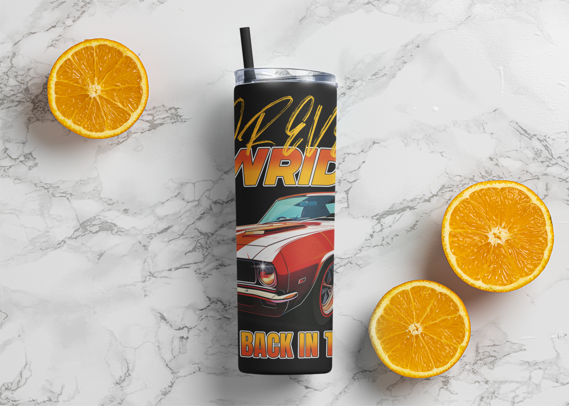 Tumbler with a car design and text on a marble surface with sliced oranges.