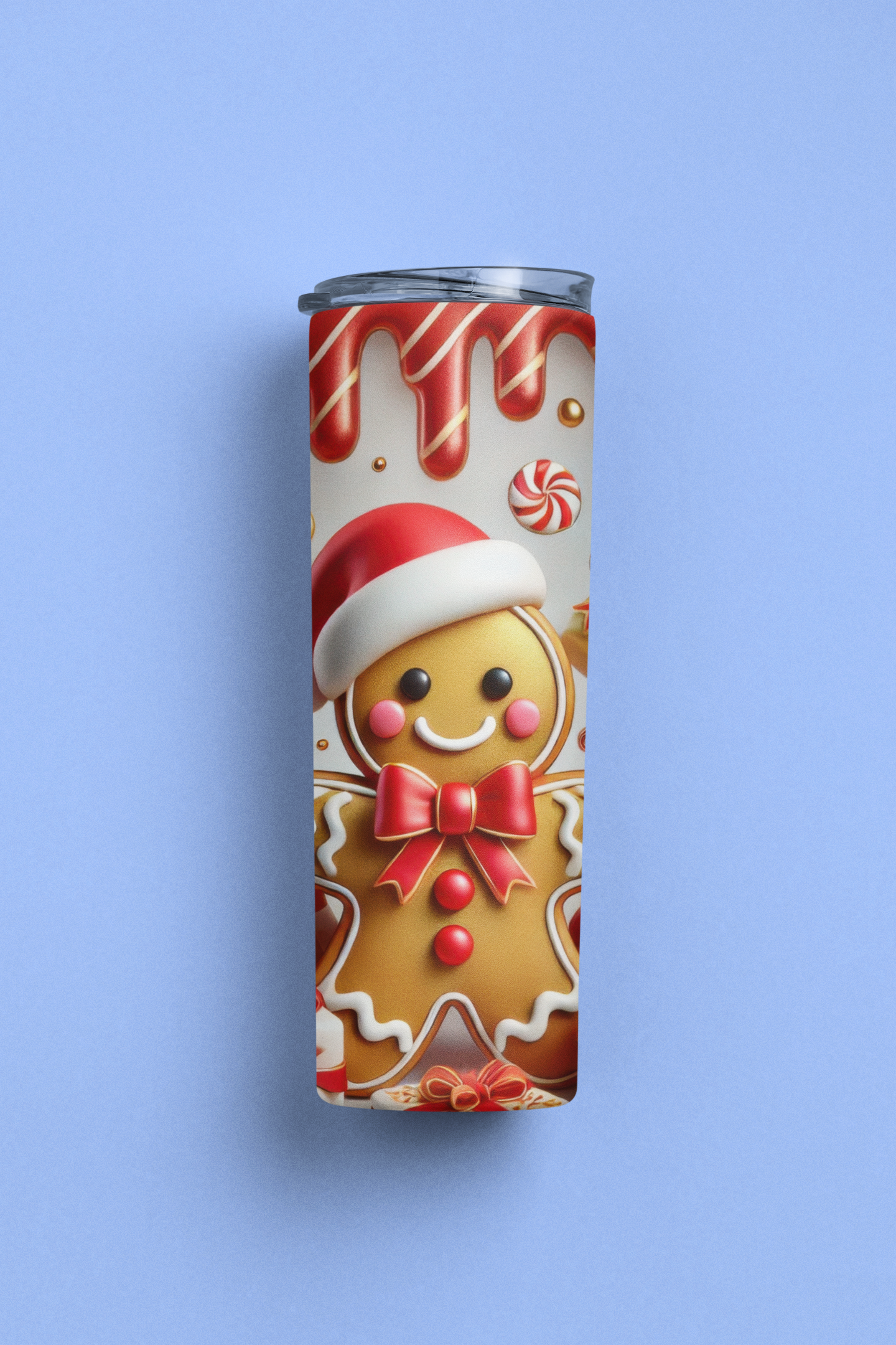 A slim stainless steel tumbler with a clear lid, featuring a festive Christmas gingerbread man print, set against a solid light blue background.