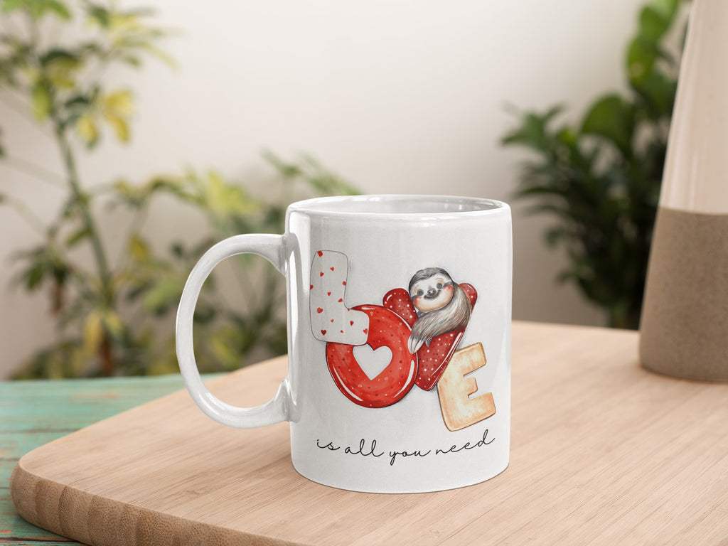 White mug with owl design and text on a wooden surface with plants in the background