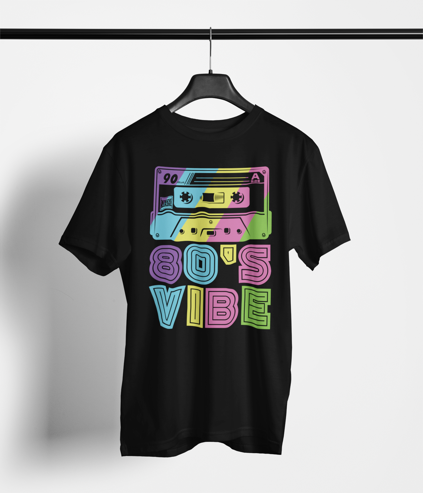 A black short-sleeve t-shirt hanging on a black hanger against a light gray wall. The shirt features a colorful retro graphic of two cassette tapes above the text '80'S VIBE' in a neon, multi-colored bubble font.