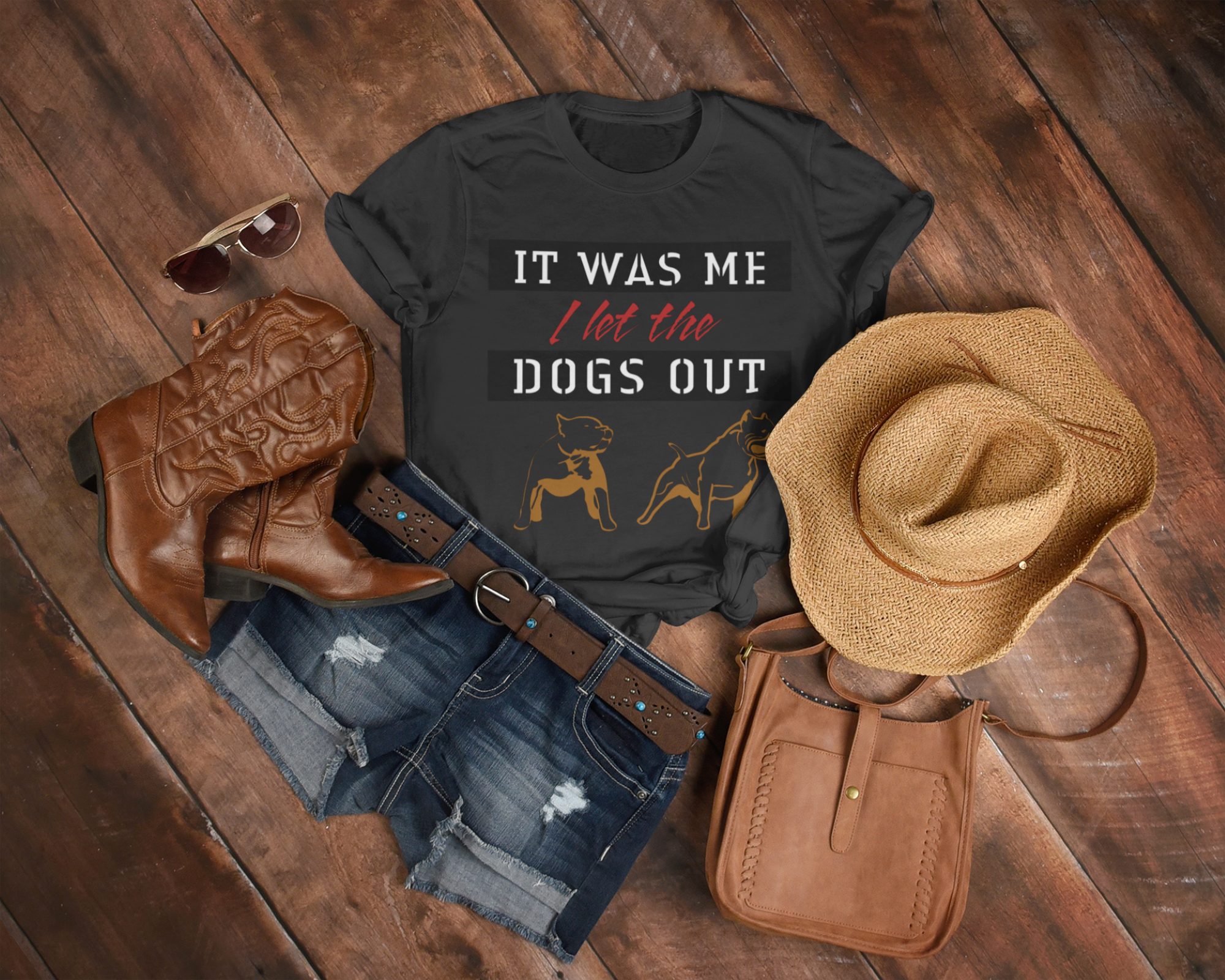 Black t-shirt with humorous text, cowboy boots, hat, and purse on a wooden surface