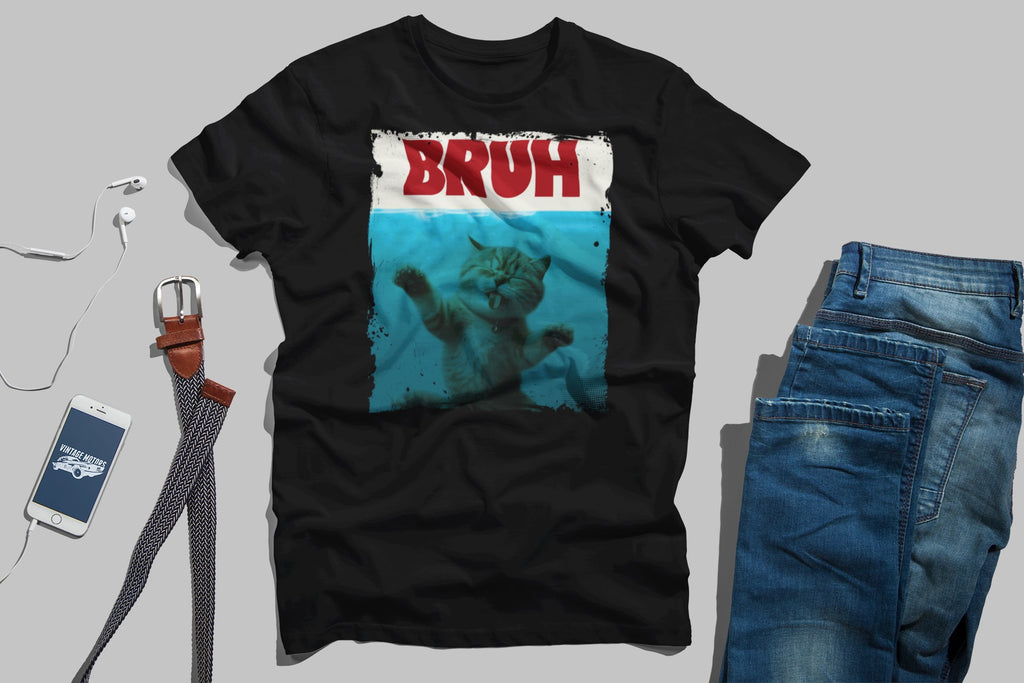 Black t-shirt with 'BRUH' graphic, blue jeans, phone, and belt on a gray background