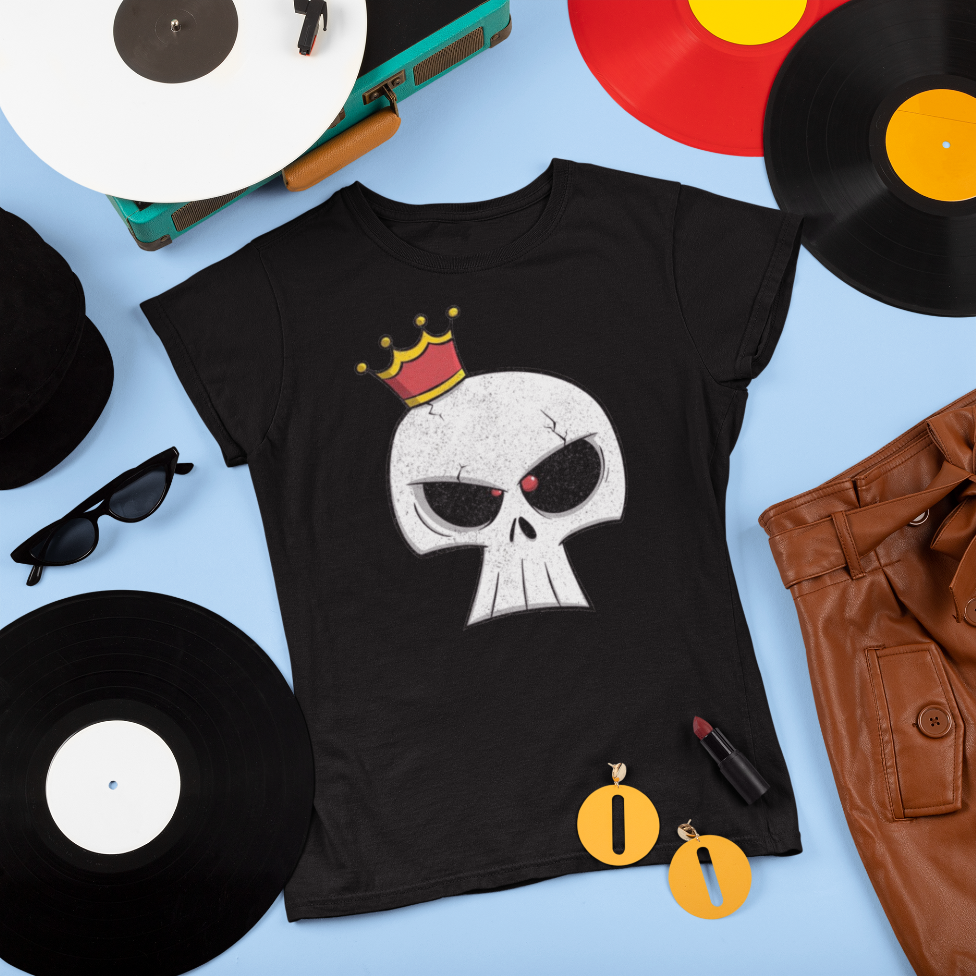 Black t-shirt with skull design and crown, surrounded by vinyl records and sunglasses on a blue background