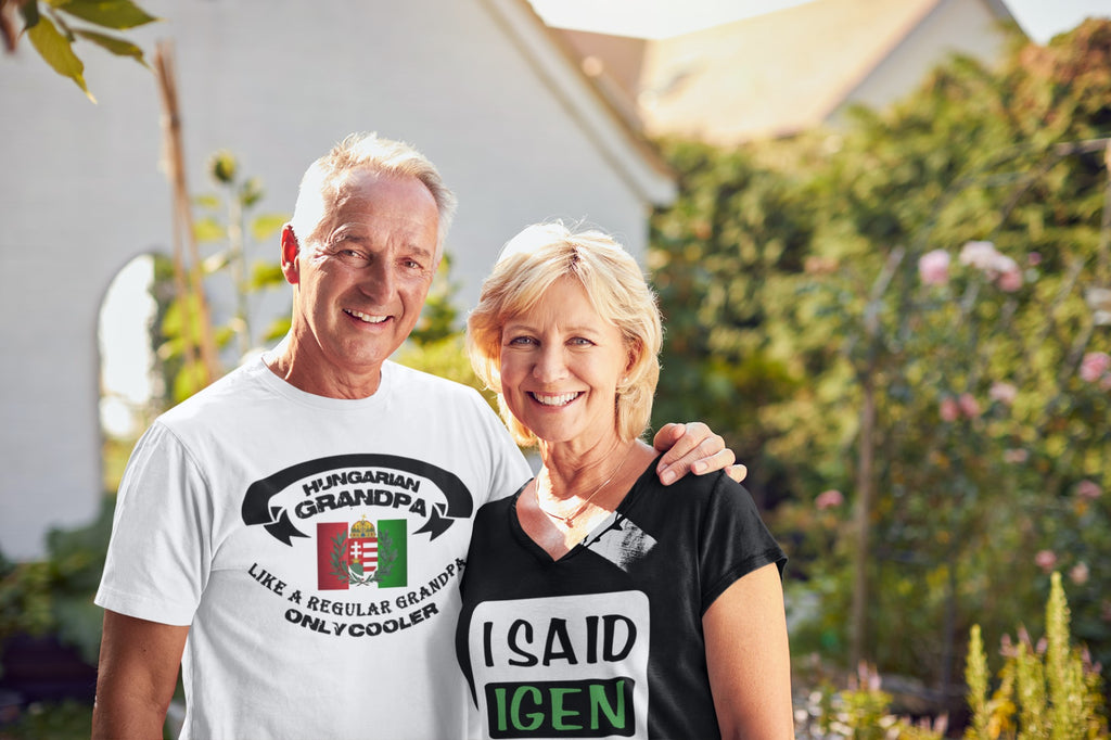 Two people standing outdoors, one wearing a white t-shirt with text and the other wearing a black t-shirt with text.