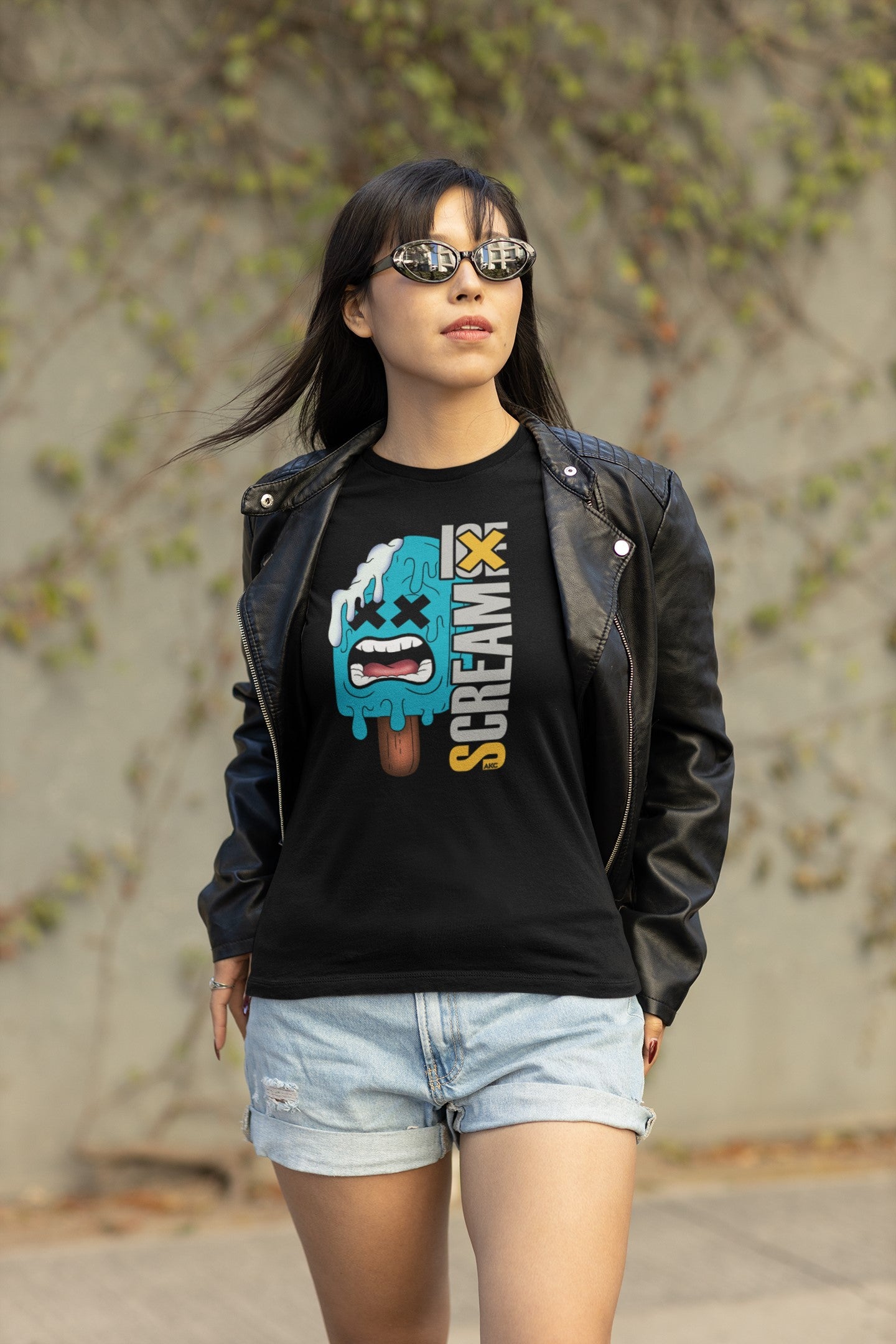 Woman wearing a black t-shirt with a graphic design and sunglasses, standing outdoors.
