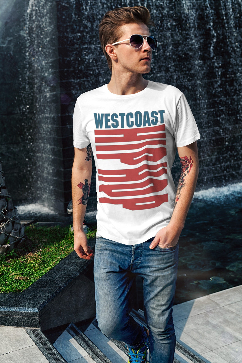 Person wearing a 'Westcoast' t-shirt standing in front of a water fountain.