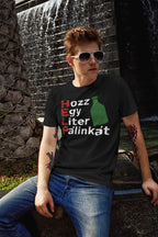 Person wearing a black t-shirt with text and graphics, sitting in front of a water fountain.