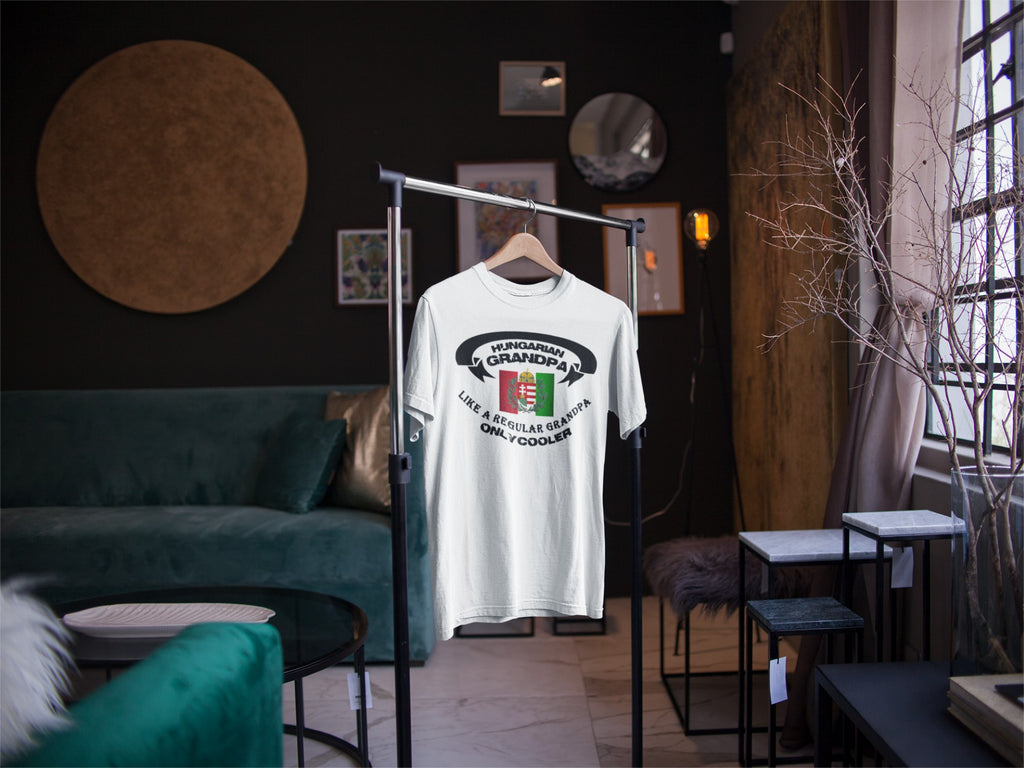 White t-shirt with graphic design on a hanger in a room with furniture and decor.