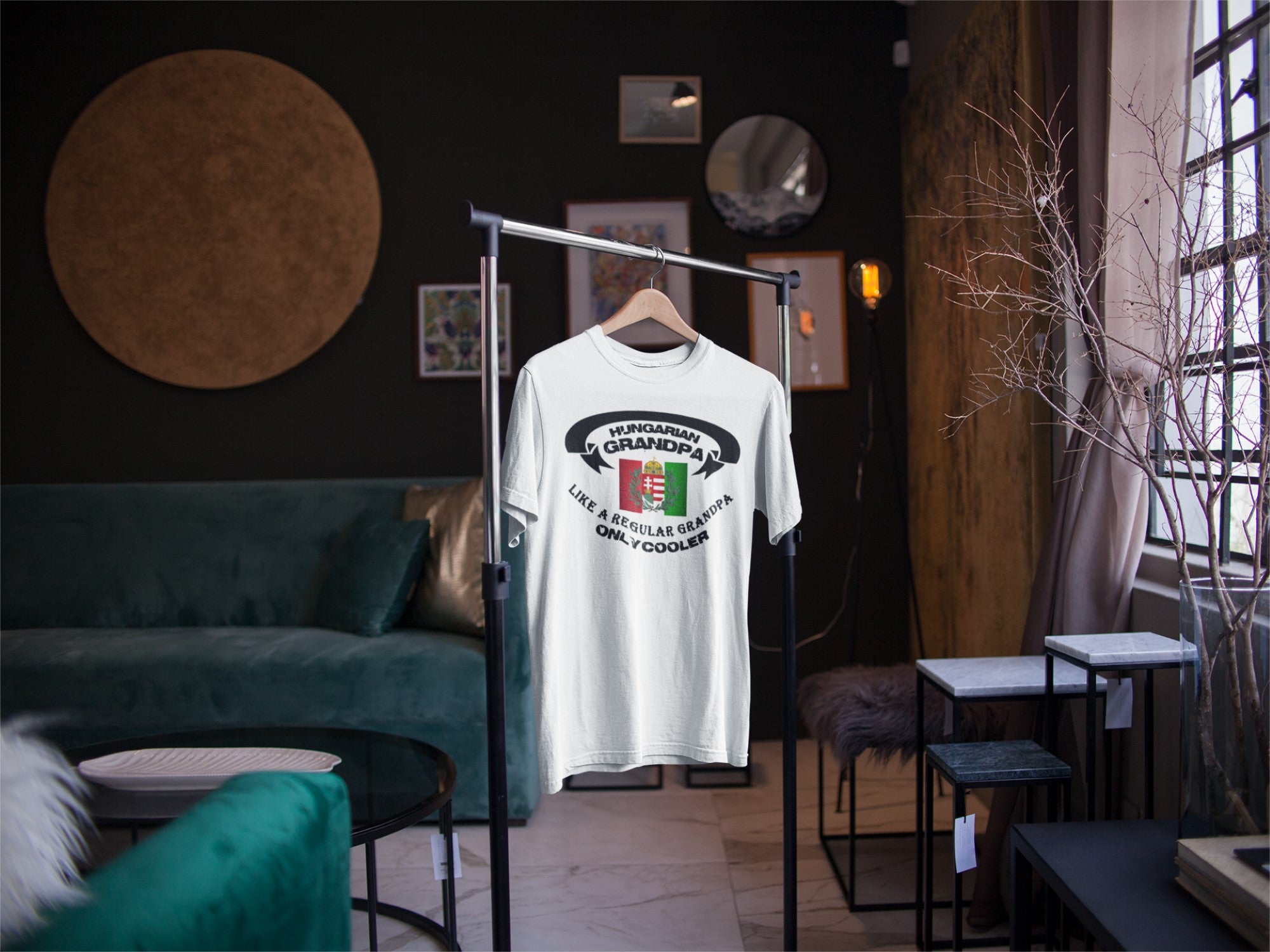 White t-shirt with graphic design on a hanger in a room with furniture and decor.