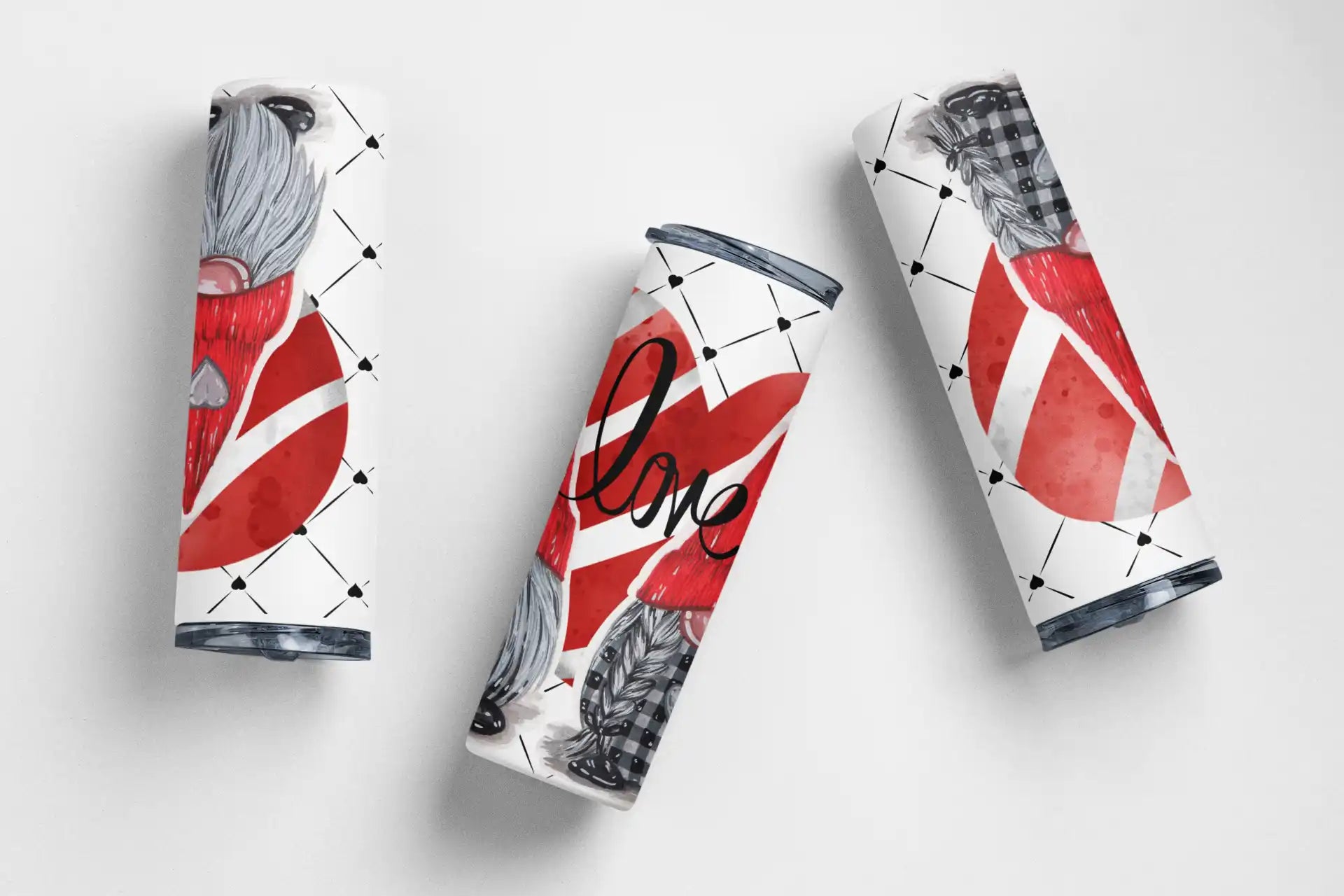Three Diet Coke cans with abstract red and white artistic designs.