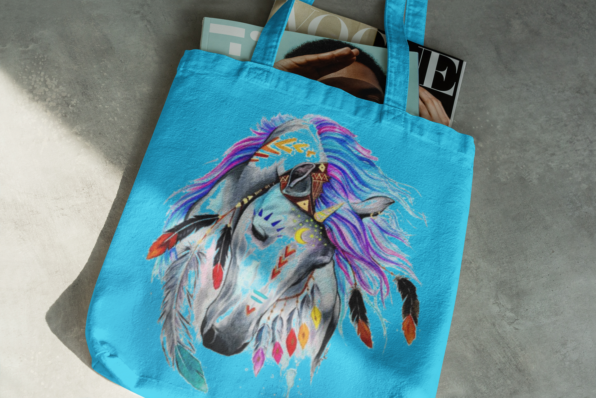 Blue tote bag with a colorful horse design on a gray surface