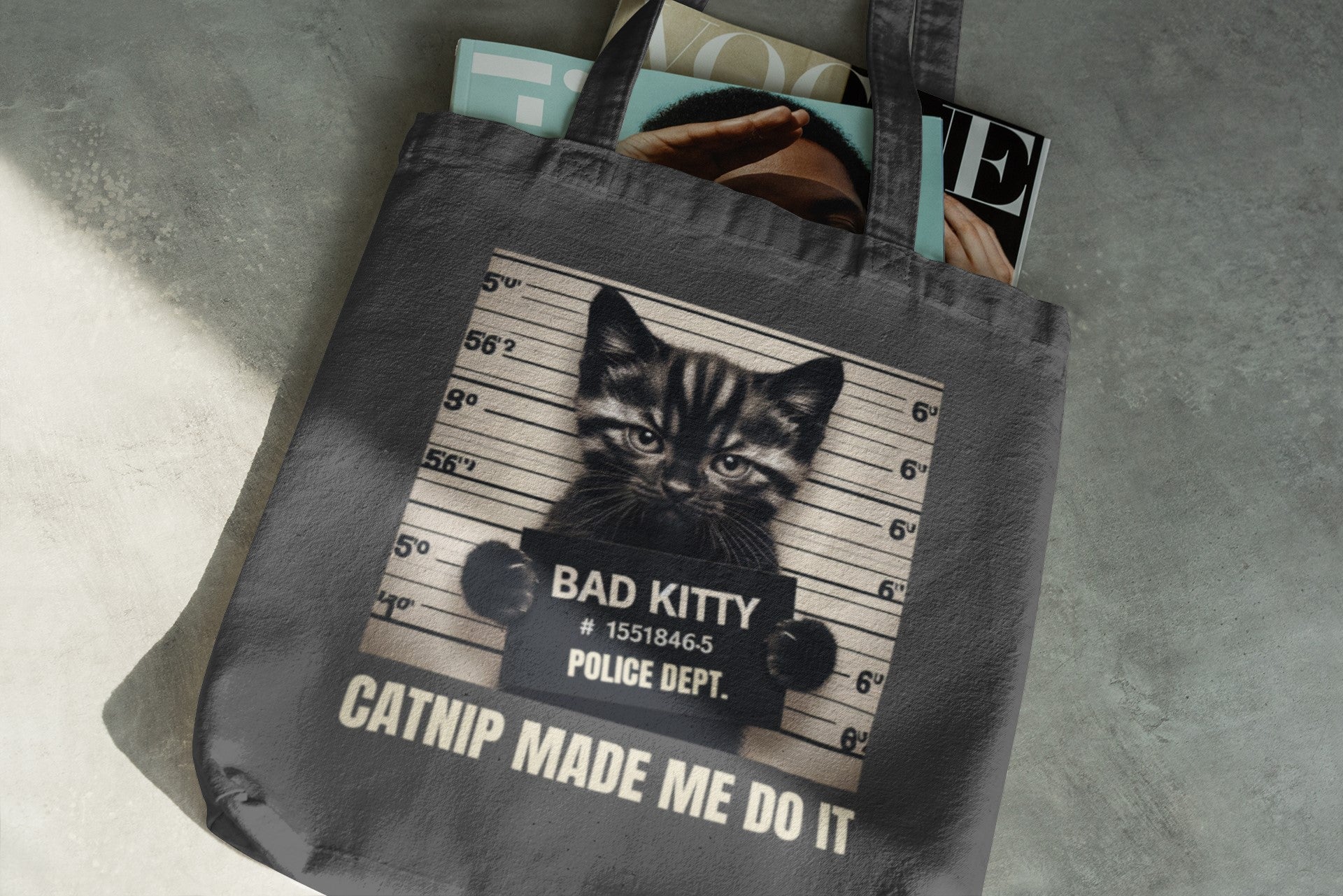 Tote bag with a cat graphic and text on a gray surface