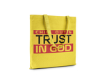 Yellow tote bag with text 'CHILL OUT & TRUST IN GOD' on a white background