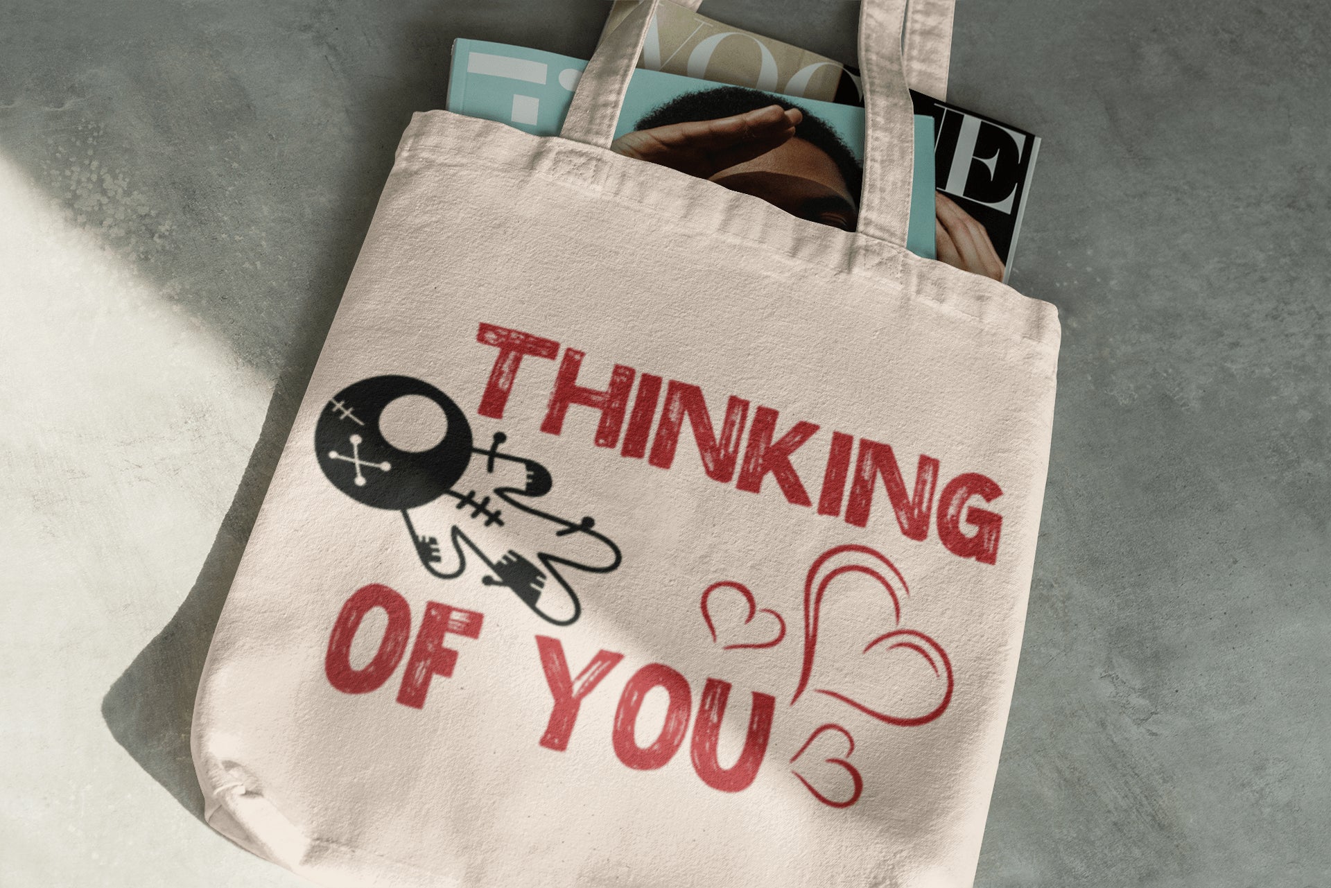 Tote bag with 'Thinking of You' text and design on a gray surface