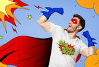 A man wearing a white graphic t-shirt with 'Boom Boom Boom!' printed on the front, styled as a comic book hero with a red cape, red mask, and blue gloves, set against a retro comic-style blue background with yellow clouds and stars.